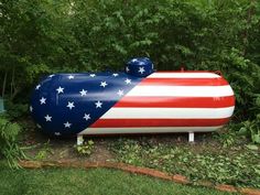 an inflatable tank with the american flag painted on it's side and trees behind it