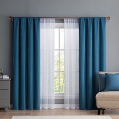 a living room with blue curtains and a white rug