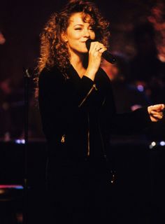 a woman singing into a microphone on stage