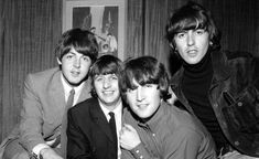 the beatles posing for a black and white photo