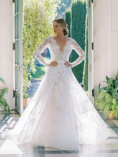 a woman in a white wedding dress standing on a tiled floor with her hands on her hips