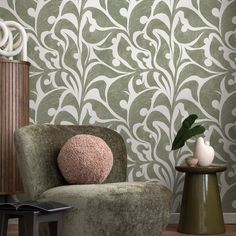 a chair and table in front of a wallpapered room with a plant on it