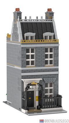 a lego model of a building with a black door and windows on the top floor