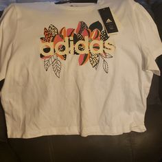 Nwt Ladies Sz Large Tshirt With Flower Design Adidas T-shirt For Spring Streetwear, White Cropped T-shirt With Logo Print For Spring, Spring White Cropped T-shirt With Logo, Casual Cotton Adidas T-shirt, Trendy Adidas T-shirt With Letter Print, White Top With Front Print For Spring, White Tops With Front Print For Spring, Trendy Adidas T-shirt For Spring, Spring Sporty Graphic Print T-shirt