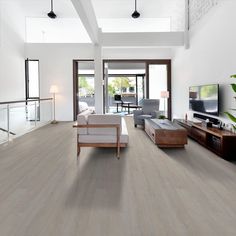 a living room filled with furniture and a flat screen tv on top of a hard wood floor