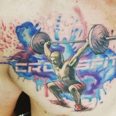 a man with a tattoo on his chest holding a barbell