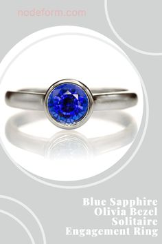 a ring with a blue sapphire in the center and an inscription below it that reads, engagement