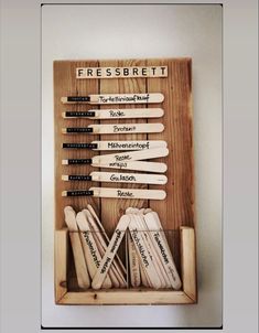 a wooden box filled with lots of different types of crochet hooks on top of a white wall