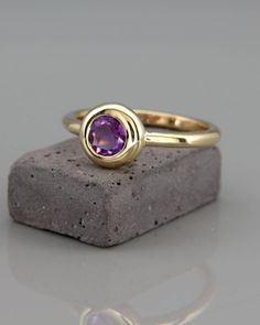 ✿ DESCRIPTION A handmade solid 14k gold ring set with a natural Amethyst. A delicate and graceful ring, carefully crafted from 14k solid  gold and set with a natural Amethyst gem. The stone bezel  designed as a ball, emphasizing the stone color and  The gentle satin finish gives the ring a luxurious royal look. THE RING Made from solid 14k gold, 2mm half-round wire. The ring in the  photos has satin matte finish. A high polished finish is also available.  The ring in the photos made from yellow Yellow Gold Solitaire Amethyst Ring With Round Cut, 14k Yellow Gold Solitaire Amethyst Ring, Timeless Yellow Gold Amethyst Ring, Timeless 14k Gold Amethyst Ring, Timeless Amethyst 14k Gold Ring, Timeless Round Amethyst Ring In 14k Gold, Yellow Gold Solitaire Amethyst Ring, Gold Amethyst Solitaire Ring In 14k Gold, Minimalist 14k Gold Amethyst Ring