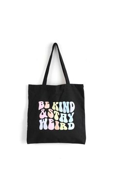 "This sturdy 12 ounce cotton canvas tote bag was screen printed with the Be Kind & Stay Weird retro wavy letters design. Printed with multi pastel rainbow colors.  Tote bag Size: 15\" L X 15\" W, Strap length: 21\"  Color: Black Follow on instagram @bonyardoddities Follow on facebook @ www.facebook.com/boneyardoddities" Affordable Black Trendy Canvas Bag, Trendy Canvas Bag With Letter Print For Everyday Use, Trendy Graphic Print Canvas Bag For Everyday Use, Trendy Everyday Canvas Bag With Letter Print, Trendy Black Canvas Bag, Trendy Canvas Bag With Graphic Print For Everyday Use, Trendy Black Cotton Canvas Bag, Everyday Retro Canvas Bag With Letter Print, Retro Everyday Canvas Bag With Letter Print