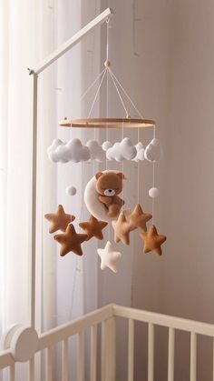 a crib mobile with teddy bears and stars hanging from it