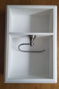 an open white box with a metal handle on the top and bottom part of it