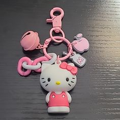 a hello kitty keychain is laying on the floor next to other toys and accessories