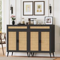 a sideboard with wicker doors and two pictures on the wall