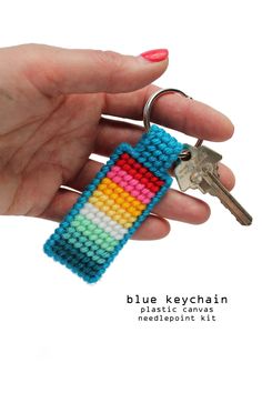 a hand holding a keychain made out of multicolored seed bead