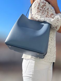 Bolso shopper creado en piel con una linea moderna. Gran bolso que está embellecido con un forro que hace contraste con el color de piel. La linea rectangular del modelo con asas grandes lo hace preciso para un día de compras. El modelo está en tres tonos, papel de azúcar, rojo y negro. Bolso de piel. Bolso fabricado en Italia. Bolso creado y fabricado en Italia. Bolso shopper de gran capacidad. Chic Square Bucket Bag For On-the-go, Chic Bucket Bag With Leather Lining For On-the-go, Leather Square Box Bag For Errands, Modern Square Soft Leather Bucket Bag, Square Bucket Bag With Leather Handles For Shopping, Chic Square Hobo Bag, Chic Square Hobo Bag For On-the-go, Modern Leather Box Bag For Errands, Chic Square Bag With Leather Lining