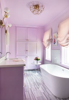 a bathroom with purple walls and flooring next to a bathtub in the corner