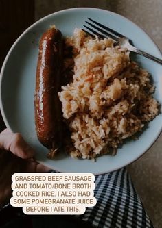 a person holding a plate with rice and a hot dog on it that says grassfed beef sausage and tomato bone broth cooked rice i also had some pomegranate juice