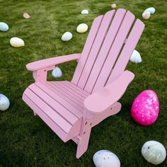 a pink lawn chair sitting in the grass next to some colored eggs on the ground