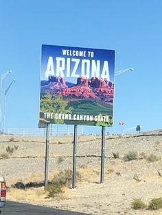 a large sign on the side of a road that says welcome to arizona with mountains in the background