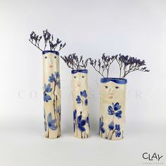 three vases with blue flowers in them on a white background, one is made out of ceramic