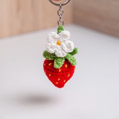 a crocheted strawberry keychain with a flower on it