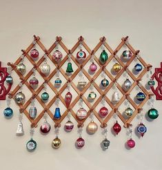 a wooden rack with ornaments hanging from it's sides and on the wall behind it