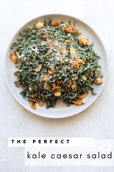 kale caesar salad on a white plate with the words, the perfect kale caesar salad