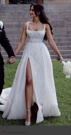 a bride and groom holding hands in front of stairs