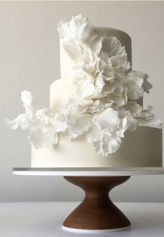 a three tiered cake with white flowers on top