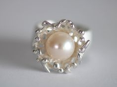 Unique ring in silver with a beautiful white pearl Size/Dimensions: Ring size 54.5 - 55 / 17.2 / 6.75 Ring rail 9.5 mm Overall width 19mm Ring size expandable up to Gr. 56 Used material: 925 silver Pearl approx. 10 mm Manufacturing method: Goldsmith handwork Unique Pearl Jewelry For Anniversary, White Pearl Charm Ring Jewelry, White Pearl Charm Ring, Unique Pearl White Jewelry For Wedding, Elegant Sterling Silver Pearl Drop Ring, Silver Ring With Pearl Charm, White Sterling Silver Pearl Ring Gift, Handmade Round Pearl Ring, Handmade Open Pearl Ring For Wedding