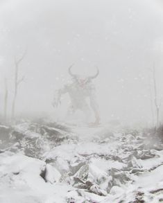 a horned animal standing in the middle of a snow covered field with trees and bushes