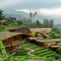 an unusual house on top of a lush green hillside with trees and mountains in the background