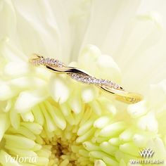 a diamond ring sitting on top of a white flower