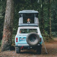 a dog is sitting in the back of a truck with its tent on it's roof