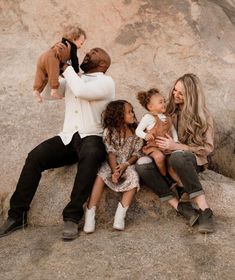 a group of people sitting on top of a rock