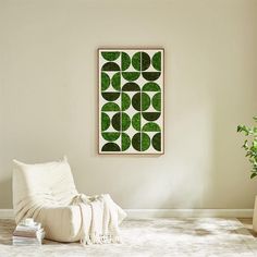 a living room with a white couch and green art hanging on the wall above it