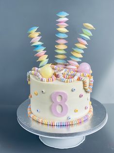 there is a birthday cake with candles in the shape of an eight on top and colorful icing