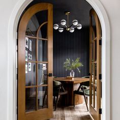 an open door leading to a dining room with a table and chairs in the center