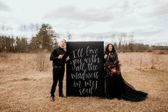 a man and woman standing next to a sign