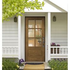 the front door of a house with flowers and plants