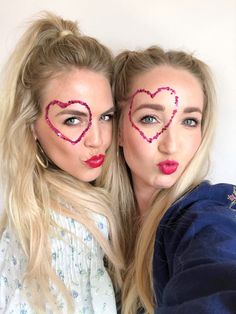 two women with hearts drawn on their faces are posing for the camera and making funny faces