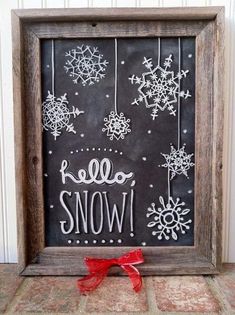 a chalkboard with snow written on it and a red bow tied to the side