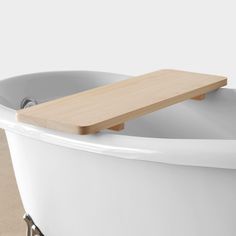 a white bath tub with a wooden handle on it