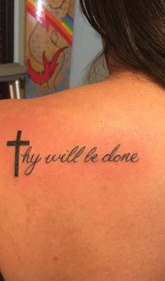 a woman with a tattoo on her back saying thy will be done