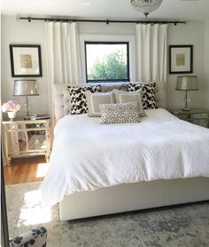 a white bed sitting under a window in a bedroom