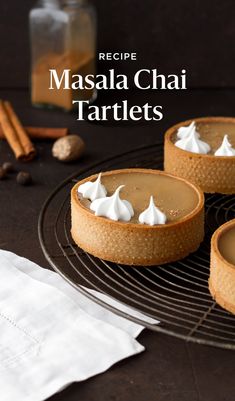 three desserts sitting on top of a cooling rack next to cinnamon sticks and nuts