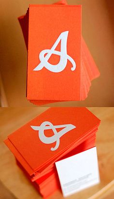 an orange business card sitting on top of a wooden table