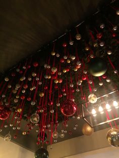 christmas decorations hanging from the ceiling in a room with red and green lights on it