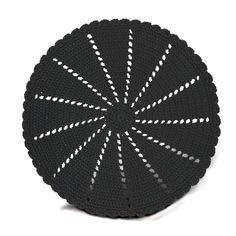 a black and white crocheted dishcloth with lines on it, in the shape of a circle